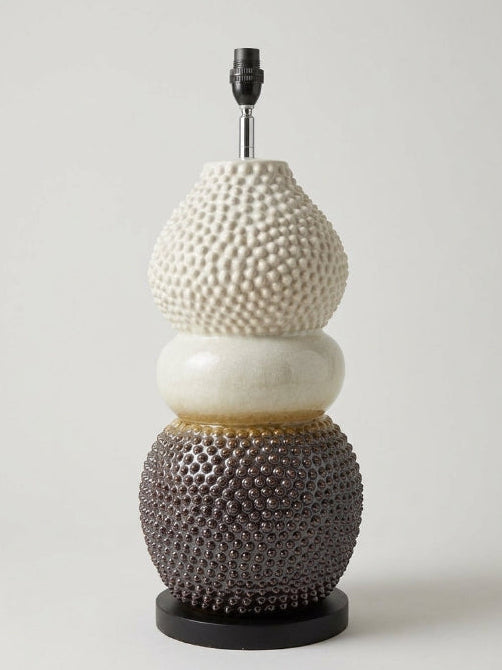 Textured ceramic table lamp base with a three-tiered stacked design featuring a white studded top section, a smooth cream middle section, and a dark brown bubble-textured bottom sphere on a black metal base.