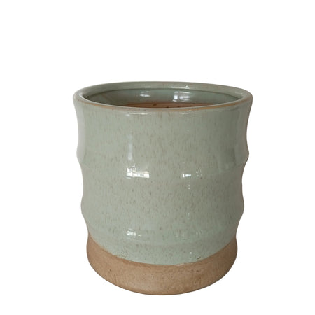 Fluted celadon green glazed ceramic planter vase with a glossy speckled upper body and a raw unglazed earthy base.