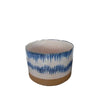 A cylindrical blue and white patterned ceramic planter with an unglazed terracotta base.