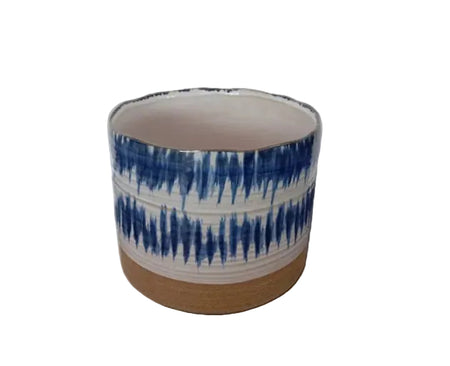A cylindrical blue and white patterned ceramic planter with an unglazed terracotta base.
