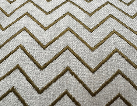 Textured off-white scatter cushion featuring a close-up of embroidered olive green and khaki zig-zag chevron patterns.