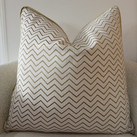 Textured off-white scatter cushion featuring a close-up of embroidered olive green and khaki zig-zag chevron patterns.