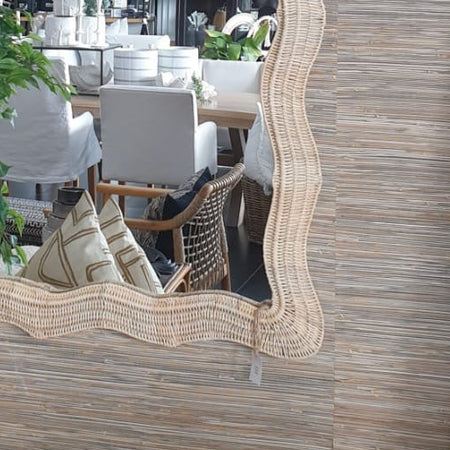 Decorative mirror with wavy frame on a wooden wall