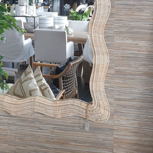 Decorative mirror with wavy frame on a wooden wall