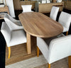 Top down view of a 2200mm solid oak oval dining table shown alongside dining chairs for scale. Table sold individually.