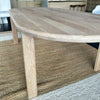 Close-up details of the smooth, clear matte lacquered natural wood grain texture on the rounded edge profile of a solid oak table.