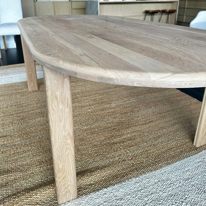 Close-up details of the smooth, clear matte lacquered natural wood grain texture on the rounded edge profile of a solid oak table.