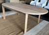 Side view showing the sturdy minimalist timber legs and premium structural joinery under the solid oak oval dining table.