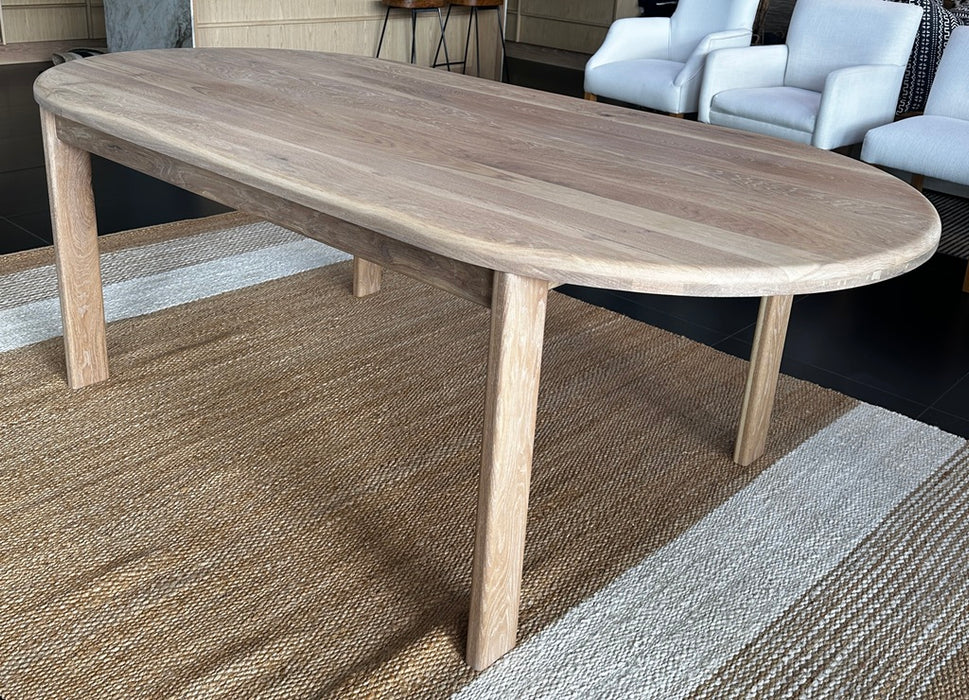 Side view showing the sturdy minimalist timber legs and premium structural joinery under the solid oak oval dining table.