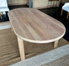Elevated view showcasing the beautiful natural timber panels, grain variations, and oval shape of the solid oak dining table.