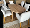Handcrafted solid oak oval dining table styled for context with upholstered linen chairs (chairs sold separately).