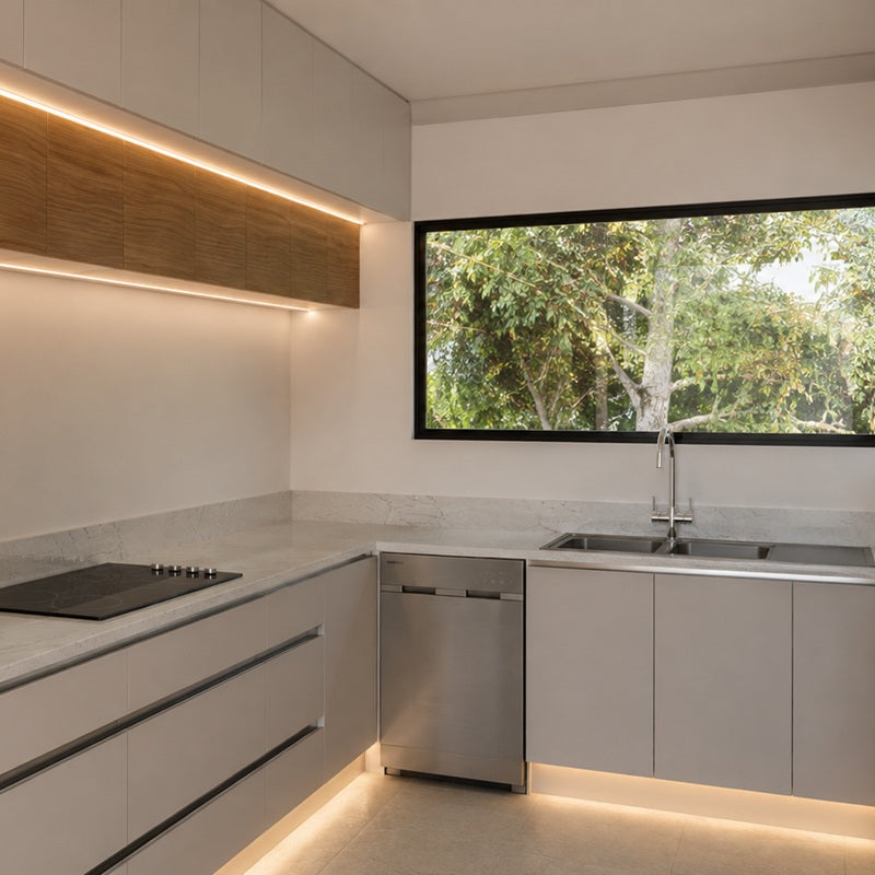 Luxury square-cropped light grey kitchen cabinetry with an integrated warm under-cabinet LED light strip and built-in modern appliances by Urban Yuppi.