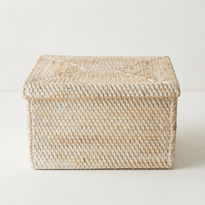 Handwoven white rattan rectangular storage basket with fitted lid.